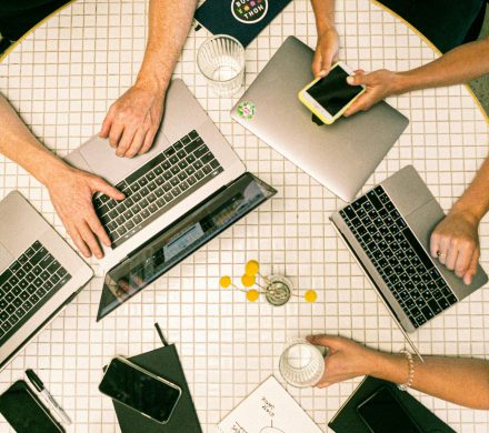 pexels photo 3194519 3194519 Top view of a team collaborating with laptops, phones, and notes in a modern office.